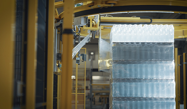 Boissons sur palette passant dans une machine d'emballage sous film étirable